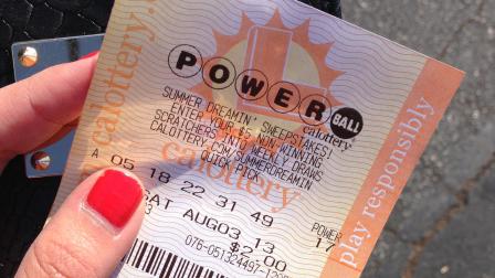 A Los Angeles resident holds up her Powerball ticket on Friday, Aug. 2, 2013.