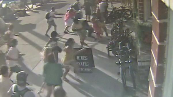 Pedestrians run out of the way of an oncoming car on the Venice Beach boardwalk Saturday, Aug. 3, 2013.