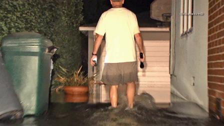 A man wades through water outside his Mar Vista home after a broken water main flooded a neighborhood on Saturday, Sept. 28, 2013.