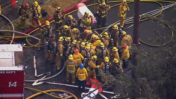 A firefighter is rescued from a burning church in Los Angeles on Tuesday, Oct. 8, 2013.