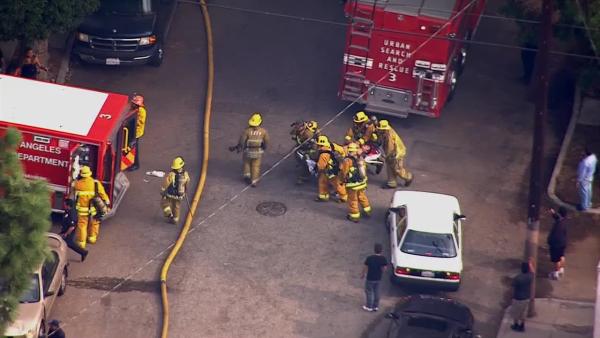 A firefighter is rescued from a burning church in Los Angeles on Tuesday, Oct. 8, 2013.