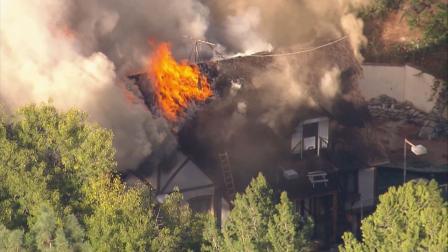 A fire burns at a mansion in Encino on Wednesday, Oct. 30, 2013.