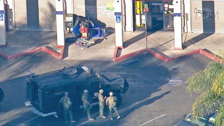Law enforcement officials gather outside of a market on the 8600 block of Hooper Avenue in Florence, where a robbery suspect barricaded himself on Wednesday, Nov. 6, 2013.