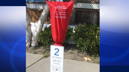 A red bag is pulled over a parking meter in downtown Manhattan Beach in this photo. The city is offering free parking for downtown shoppers over the holiday season.
