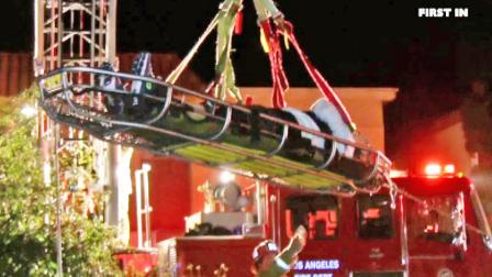 A person is shown being lifted out of a wash near Parthenia Street and Noble Avenue in North Hills following a hit-and-run crash on Thursday, Dec. 26, 2013.