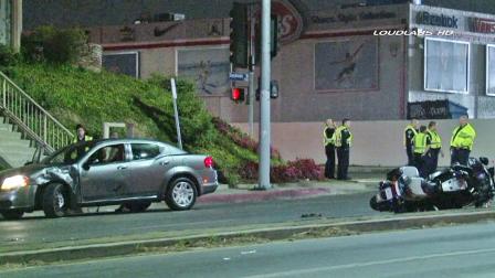 Police officers investigate the scene of a car crash involving a Los Angeles Police Department motorcycle officer in Van Nuys on Saturday, Jan. 11, 2014.