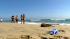 Beachgoers in Newport Beach look out to the...
