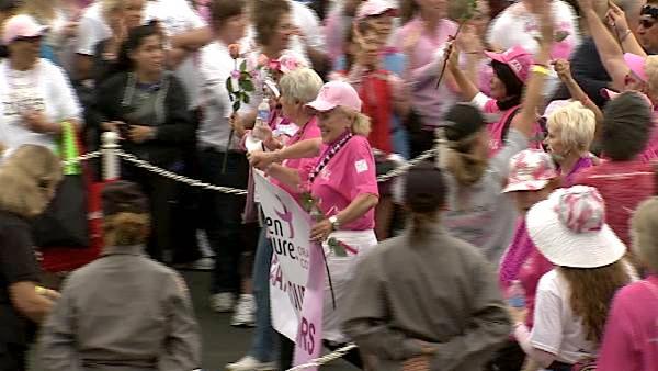 Participants holding a banner make their way through the crowd at the Susan G. Komen Race for the Cure event, which drew more than 30,000 supporters to Newport Beach on Sunday, Sept. 25, 2011.