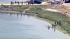 Surfers enter the Bolsa Chica wetlands in...