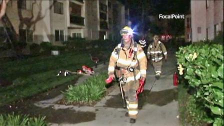 Firefighters are seen at a Rossmoor apartment building where a fire broke out Monday, July 9, 2012. Two off-duty officers were credited with helping evacuate people from their units during the fire.