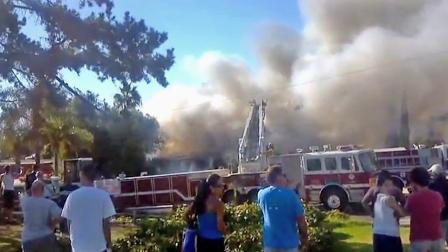 A still from amateur video shows smoke from a house fire in Buena Park on Sunday, Sept. 16, 2012. A driver who passed by the blaze ran inside the home and rescued an 80-year-old woman from the flames.