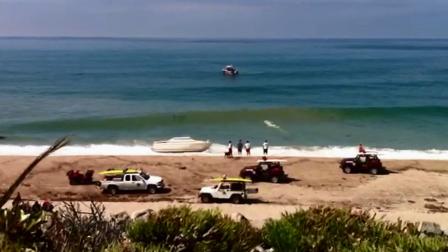 Law enforcement officials are seen at a beach in Orange County, where a boat came ashore with 10 suspected illegal immigrants on board on Monday, Sept. 17, 2012.