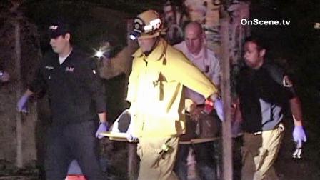 First responders are seen carrying a pursuit suspect to an ambulance after the suspect fell from a 91 Freeway bridge after the vehicle he was in crashed in Bellflower on Monday, Oct. 29, 2012.