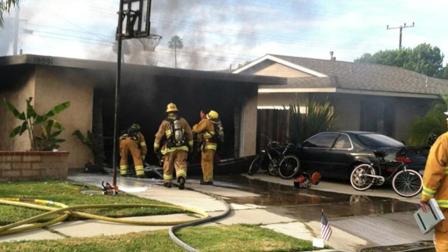 Firefighters at the scene of a house fire on the 19000 block of Woodward Lane in Huntington Beach.