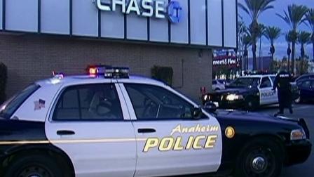 Anaheim police are seen at a parking lot for a Chase bank, where a woman was attacked with a hammer on Tuesday, Dec. 18, 2012.