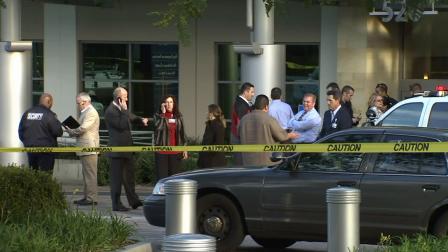 Investigators stand outside a medical office where a doctor was shot and killed on Monday, Jan. 28, 2013.