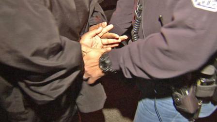 A juvenile is detained by an Orange County law enforcement official during a curfew sweep on Thursday, May 9, 2013.