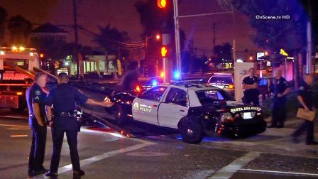A damaged police vehicle is loaded onto a tow truck in Santa Ana on Monday, Aug. 12, 2013.