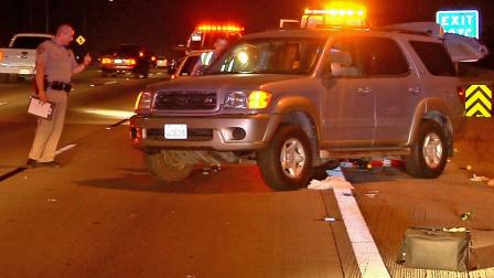 A California Highway Patrol officer surveys the scene of a crash on the 5 Freeway in the city of Orange on Thursday, Aug. 22, 2013.