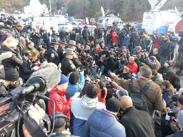 Media crowd Connecticut officials holding a news...