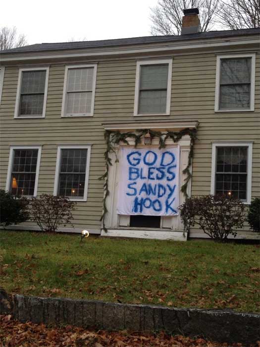A sign is hung on the doorway in Newtown, Conn. on Sunday, Dec. 16, 2012. Friday, a gunman opened fire and killed 26 people, including 20 children, before turning the gun on himself, at Sandy Hook Elementary School.