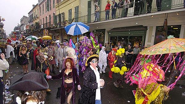 Mardi Gras revelers parade down Royal Street in the historic French Quarter.