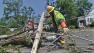 A utility worker is seen picking up a downed power line in an East Coast neighborhood in this photo. Deadly summer storms killed over a dozen people and left millions without power in June 2012.