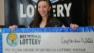 A woman who won the lottery in Michigan is shown holding her jackpot check for $1 million.