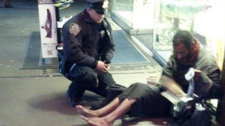 An NYPD officer gives a shoeless homelsess man a pair of boots in New York City, Nov. 27, 2012.