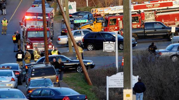 Emergency vehicles line the road at a firehouse staging area for family at the entrance to Sandy Hook School, the site of a school shooting in Newtown, Conn., Friday, Dec. 14, 2012.