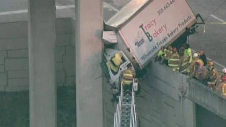 A bakery delivery truck is shown dangling off the side of an overpass ramp in Florida on Wednesday, Feb. 06, 2013.
