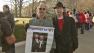 Two men stand side-by-side outside the Supreme Court holding a sign that reads, Together 34 yrs.