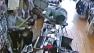 A Chicago store owner swings a bt to fend off armed robbers in this surveillance still image.
