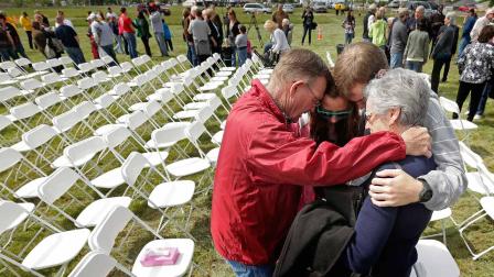 Churchgoers huddle to pray after a service for the First Baptist Church in a field Sunday, April 21, 2013, four days after an explosion at a fertilizer plant in West, Texas.