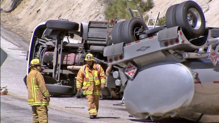 Firefighters examine an overturned tanker that was transporting fuel when it flipped over in Angelus Oaks on Friday, April 26, 2013. The accident shut roads and caused a hazard to the nearby Santa Ana River Basin.