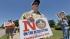 Matthew Ray, 15, of North Richland Hills, Texas, holds signs near where the Boy Scouts of America are holding their annual meeting Wednesday, May 22, 2013, in Grapevine, Texas.