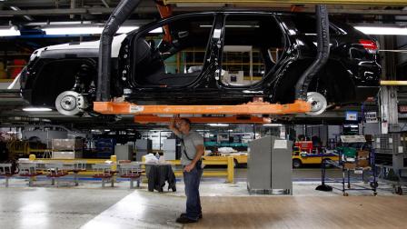 FILE- In this Wednesday, May 8, 2013, file photo, Jeff Caldwell, 29, right, a chassis assembly line supervisor, checks a vehicle on the assembly line at the Chrysler Jefferson North Assembly plant in Detroit.