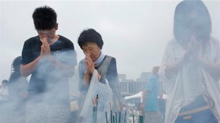 People pray for the atomic bomb victims at the Hiroshima Peace Memorial Park in Hiroshima, western Japan, Tuesday, Aug. 6, 2013.