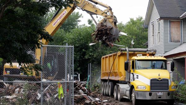 Debris is loaded onto a truck at a house where three women were held captive and raped for more than a decade, Wednesday, Aug. 7, 2013, in Cleveland.