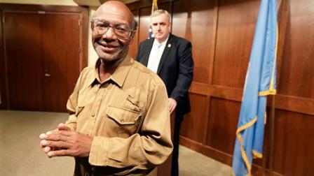Glen James, of Boston, left, smiles in the direction of members of the media as Boston Police Commissioner Edward Davis, right, looks on during a news conference at the police headquarters, in Boston on Monday, Sept. 16, 2013.