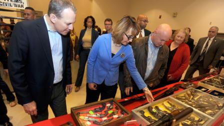 New York Attorney General Eric Schneiderman, left, former Arizona congresswoman Gabrielle Giffords, center, and her husband Mark Kelly tour the New EastCoast Arms Collectors Associates arms fair in Saratoga Springs, N.Y. on Sunday, Oct. 13, 2013.