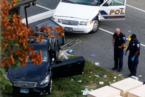 Capitol Hill police officers look at a car...