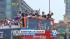 Los Angeles Kings players wave from atop a bus...