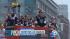Los Angeles Kings players wave from atop a bus...