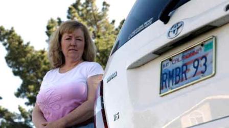 In this April 21, 2012, photo, Candice Hoglan poses for a portrait with her vehicle with a license plate commemorating the events of Sept. 11, 2001, in Sunnyvale, Calif.