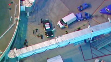 Officials are shown at San Diego Lindbergh Field, where a man was arrested for running onto the tarmac on Thursday, Jan. 17, 2013.