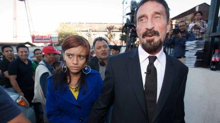 Software company founder John McAfee, right, accompanied by his girlfriend Sam, leaves after a press conference outside the Supreme Court in Guatemala City, Tuesday, Dec. 4, 2012.