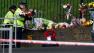 Police officers lay down floral tributes handed to them by members of the public at the scene of a terror attack in Woolwich, southeast London, Thursday, May 23, 2013.