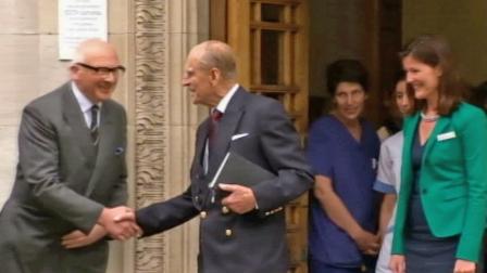 Prince Philip shakes hands with people as he leaves a hospital in London Monday, June 17, 2013.