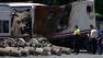 Police and security officers look at a wrecked carriage in a train depot in Padron, near Santiago de Compostela, Spain, Friday July 26, 2013 after it was taken there from the scene of a train accident.